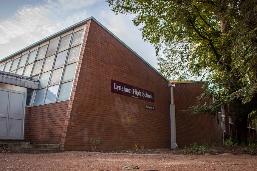 The side of a brick building with a sign that reads 'Lyneham High School'.
