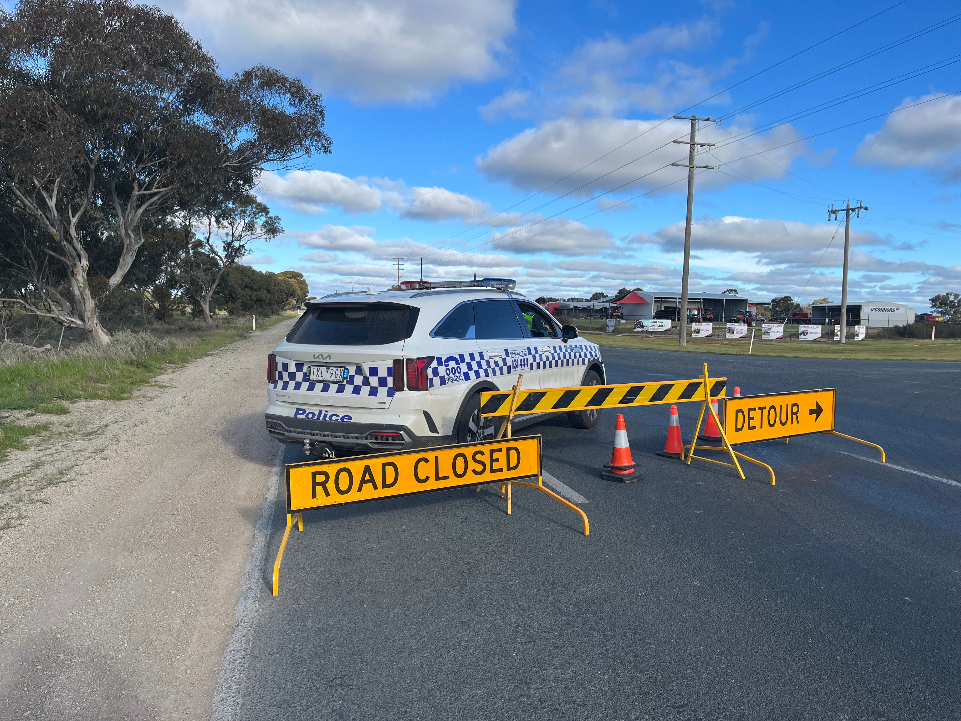 A police car and road closure signs on a highway.