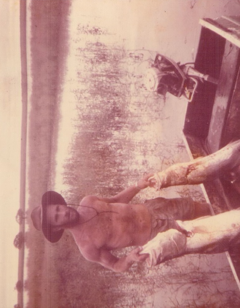 A young Bill Dean holds Barramundi in the bush