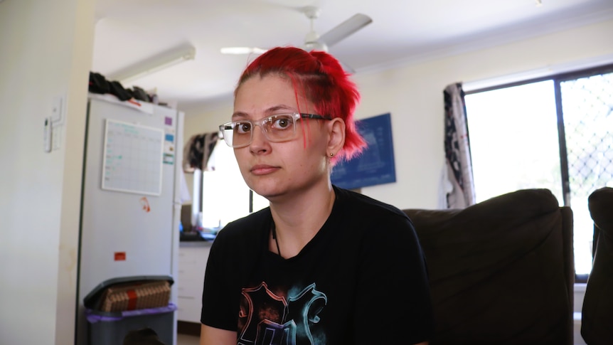 Woman looks at camera with neutral expression