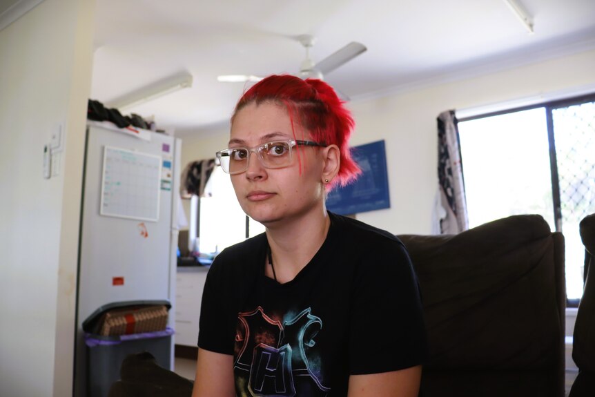 Woman looks at camera with neutral expression