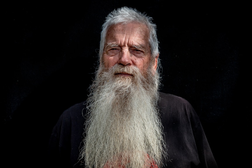 A portrait of an older man with white hair and a long white beard