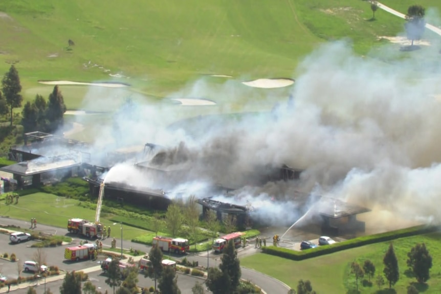 A building on fire at a golf course