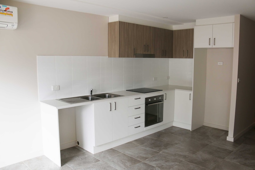 Inside one of the new public housing units in Lyneham featuring the kitchen and air conditioning unit.