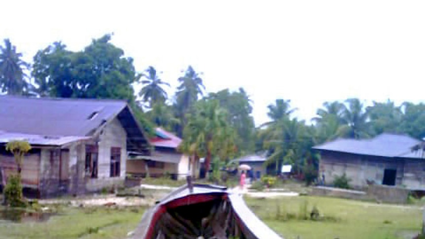 A boat sits on grass in Indonesia disaster aftermath