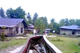 A boat sits on grass in Indonesia disaster aftermath