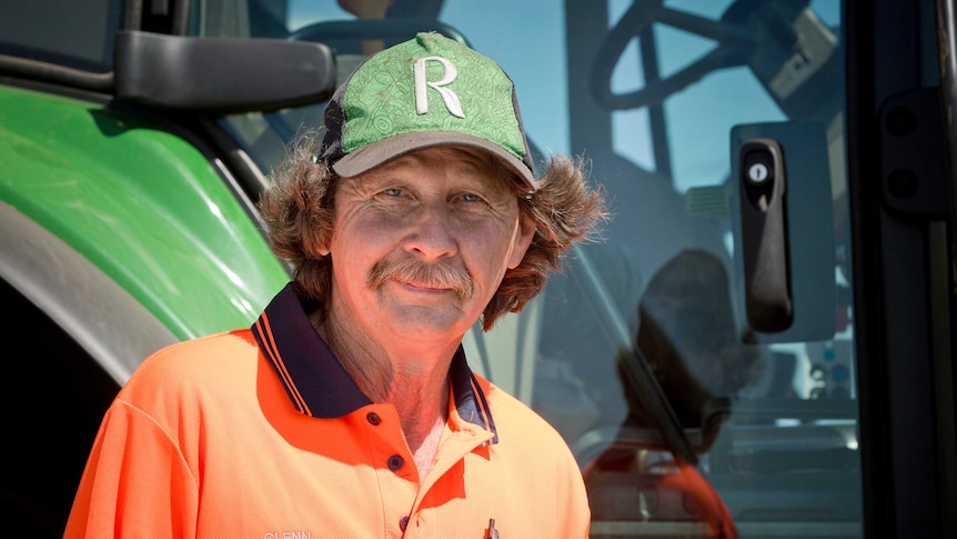 Glenn Bressow stands outside a tractor he drives as part of his job at Rocky Point.