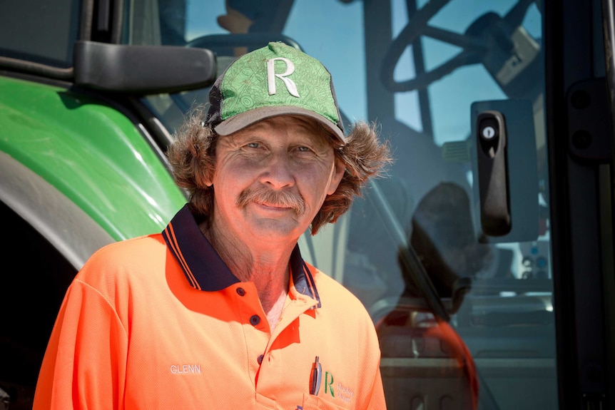 Glenn Bressow stands outside a tractor he drives as part of his job at Rocky Point.