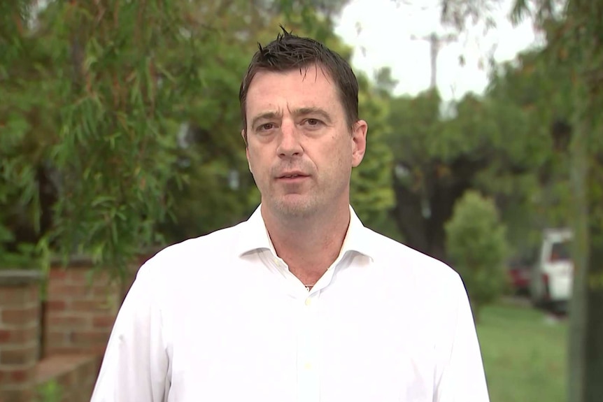 A man standing in the street talking.