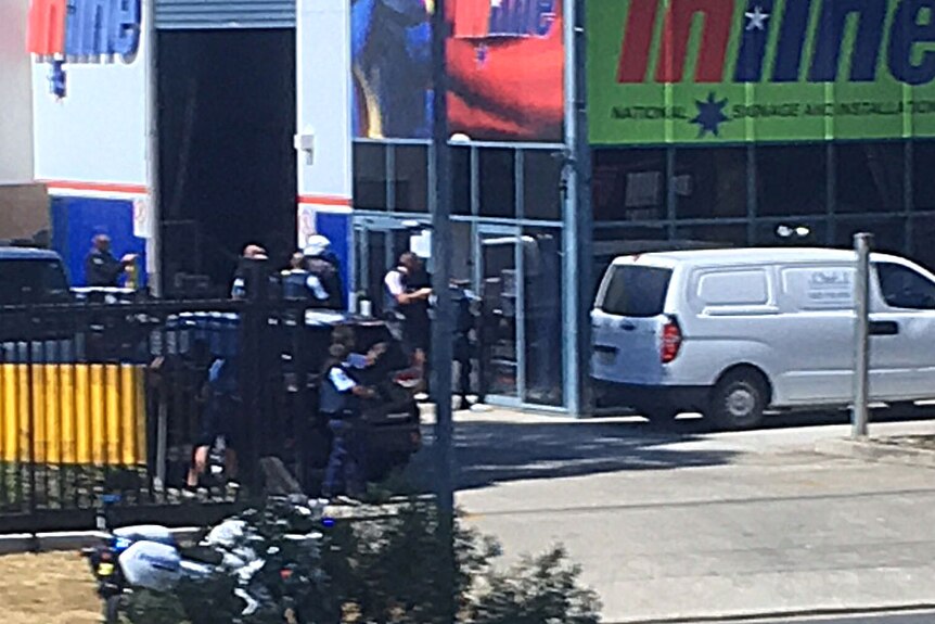 Photo from across the street of heavily armed police surrounding Inline National Signage
