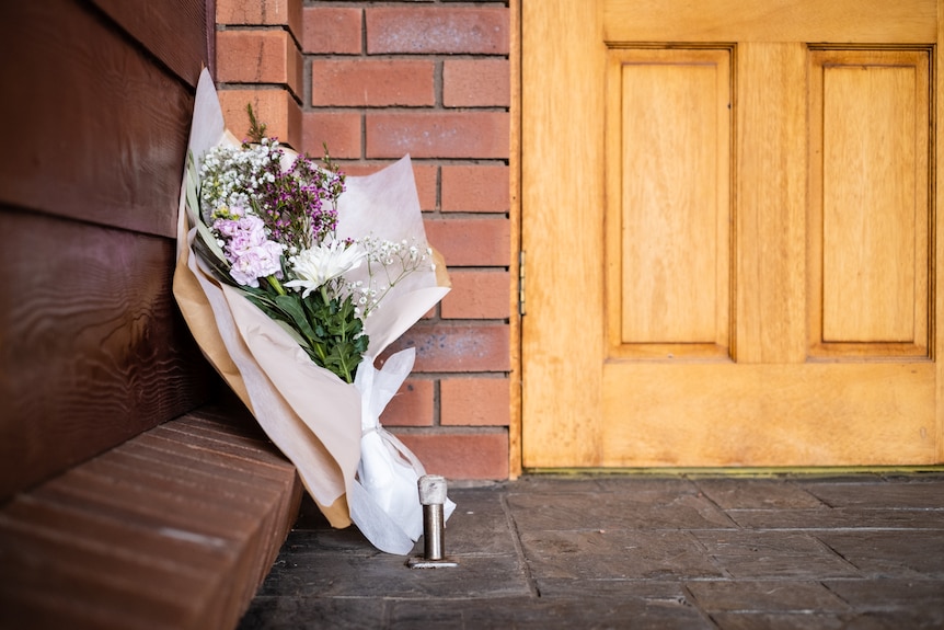 A bouquet of flowers sits at the door of a Kingdom Hall