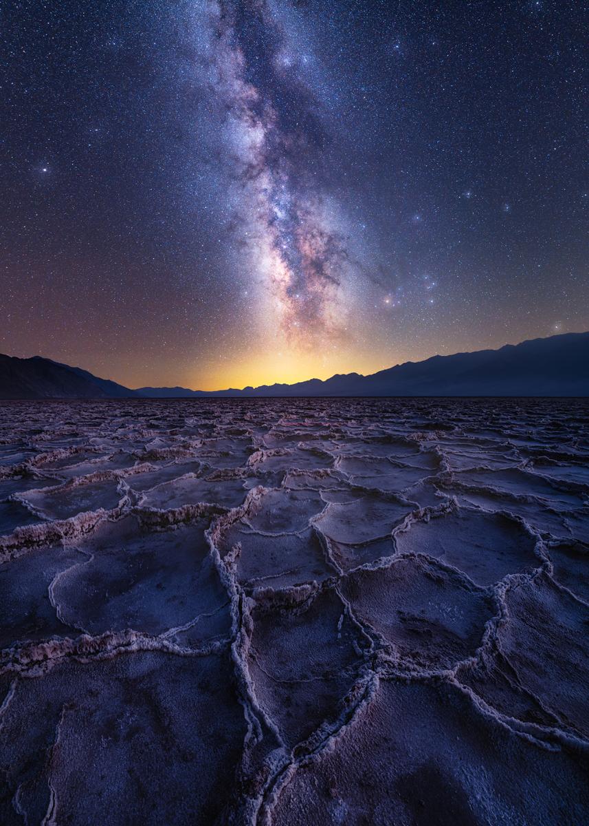 Galaxias azules que brillan intensamente estrellas en la distancia sobre grasas saladas de formas hexagonales. 