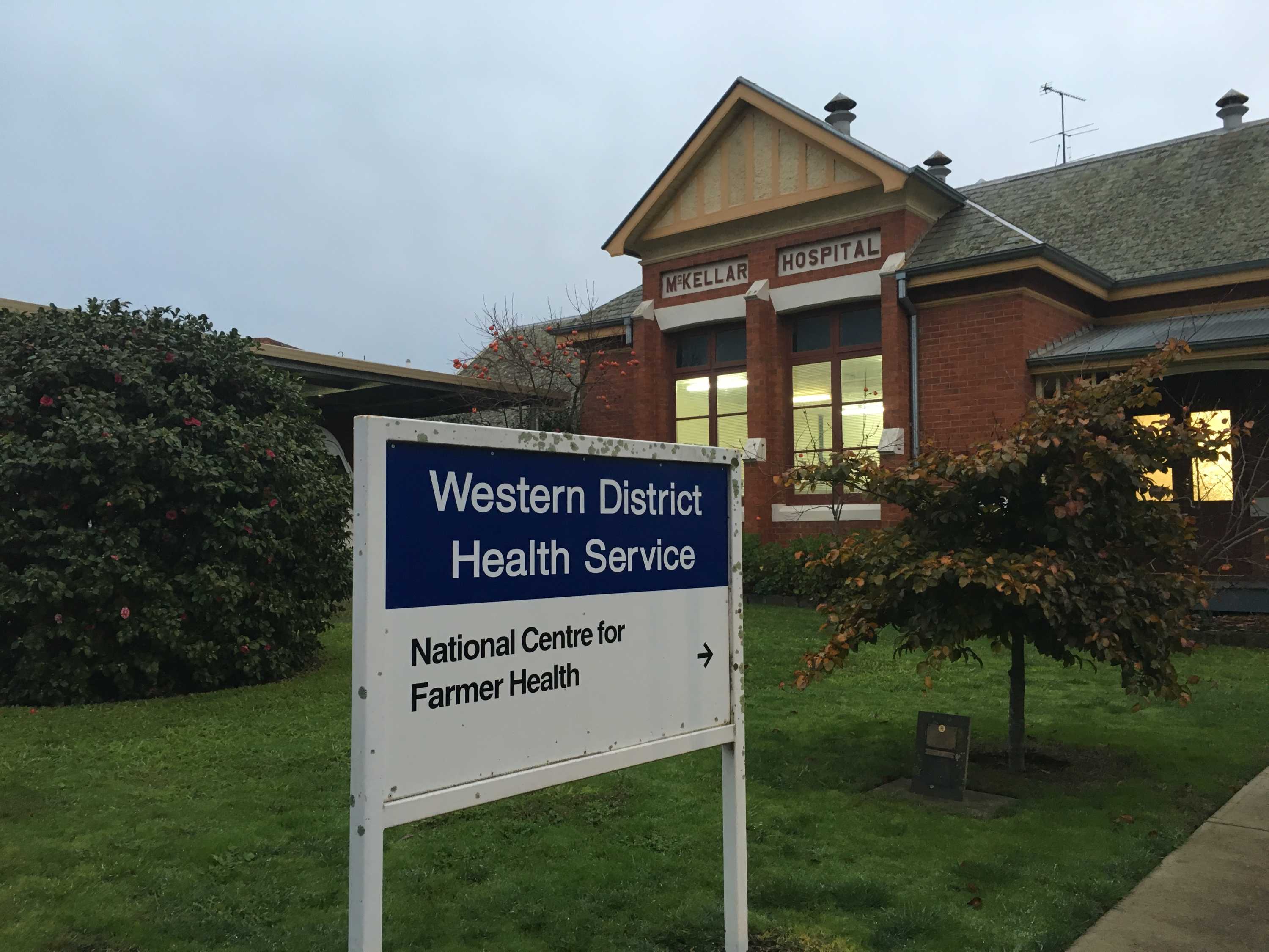 An older-style low-set building with a sign out the front.