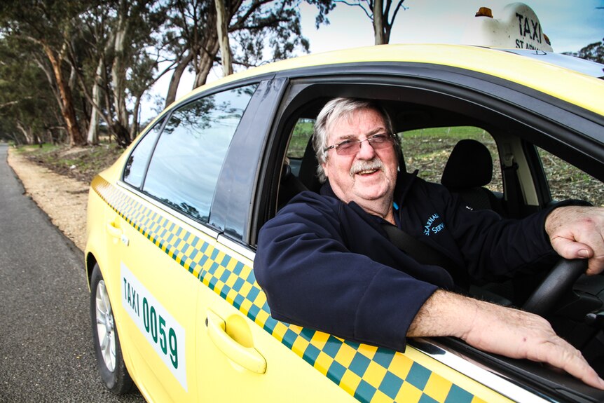 Murray Bartlett behind the wheel of his taxi on a country road in St Arnaud.