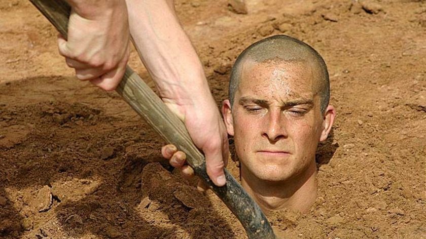 Bear Grylls is buried up to his neck in earth