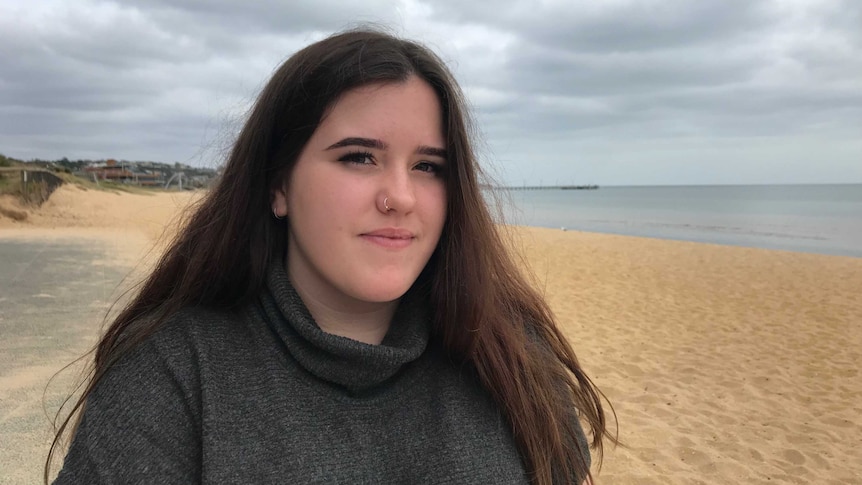 Skye De Jarlais sitting on the beach in Frankston.