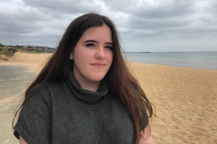 Skye De Jarlais sitting on the beach in Frankston.