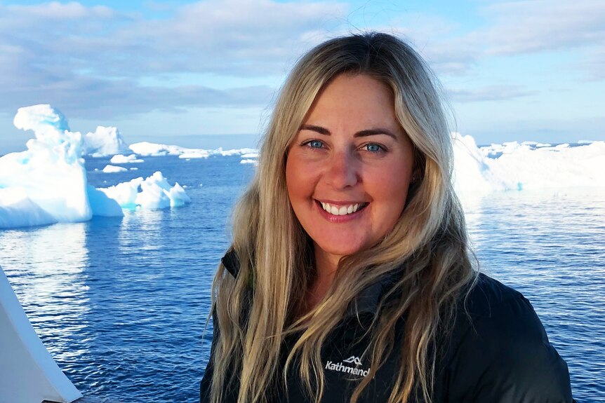 Lead researcher at Project Orca Dr Bec Wellard on a boat with the ocean and ice bergs in the background.
