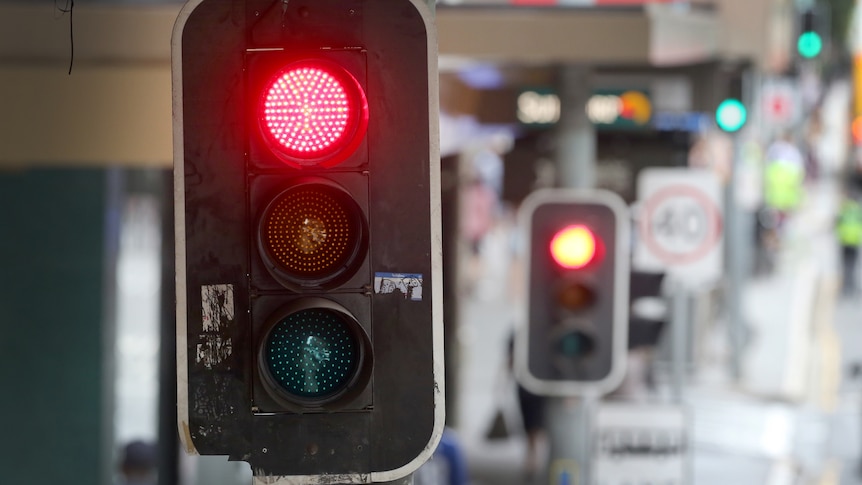 a close-up of a traffic light box, the red light is glowing