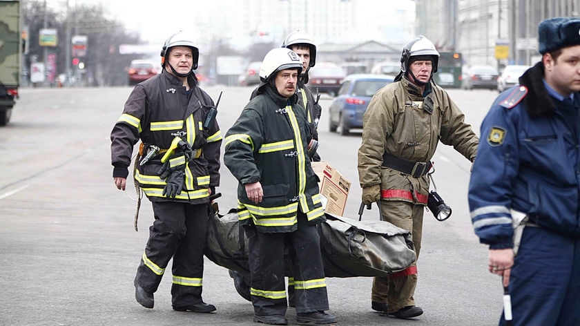 Firemen carry away the remains of victims