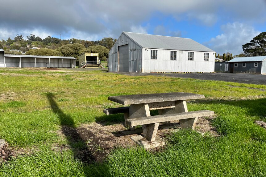 An old shed and picnic bench on lawn