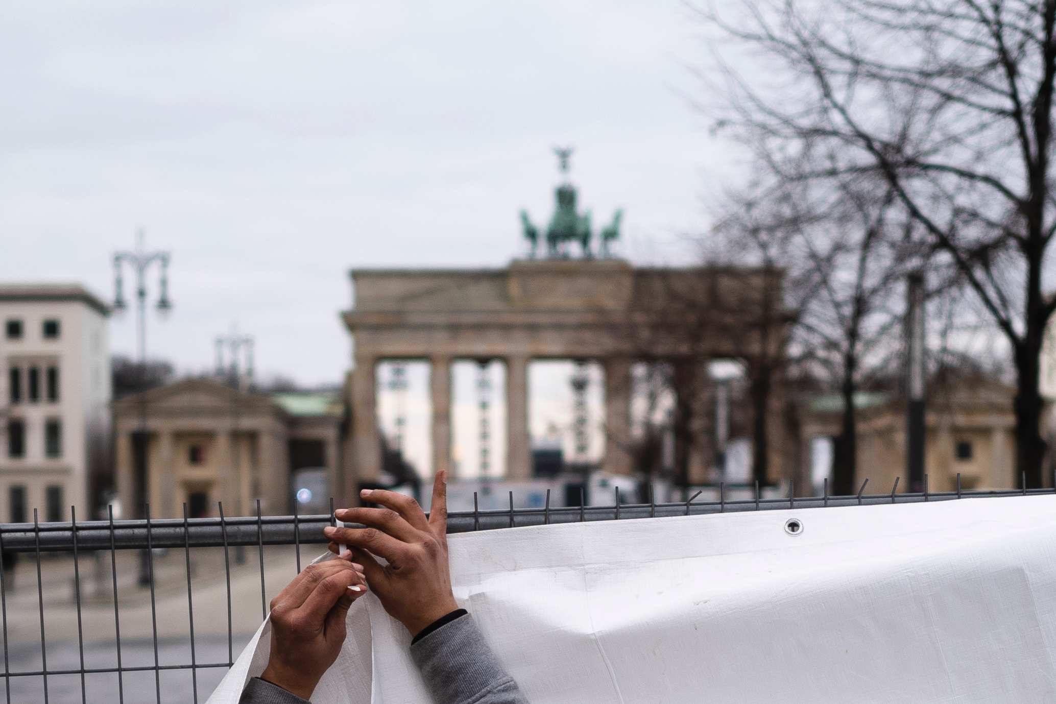 A man sets up a fence in front of the Brandburg Gate.
