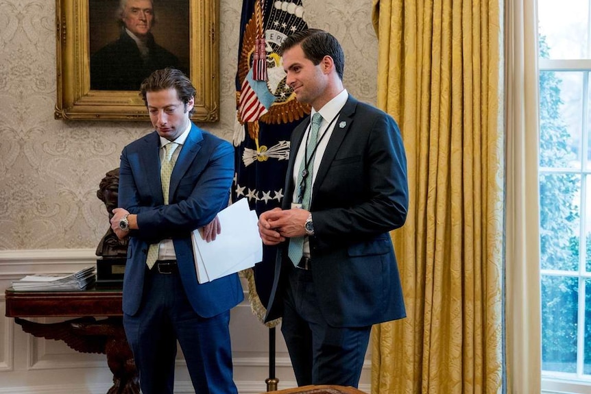 John McEntee stands with another official in the Oval Office.