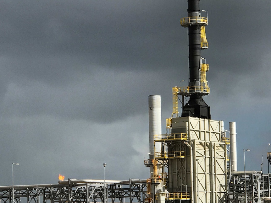 A flame bursts from the top of the metal cages at the Longford gas plant.