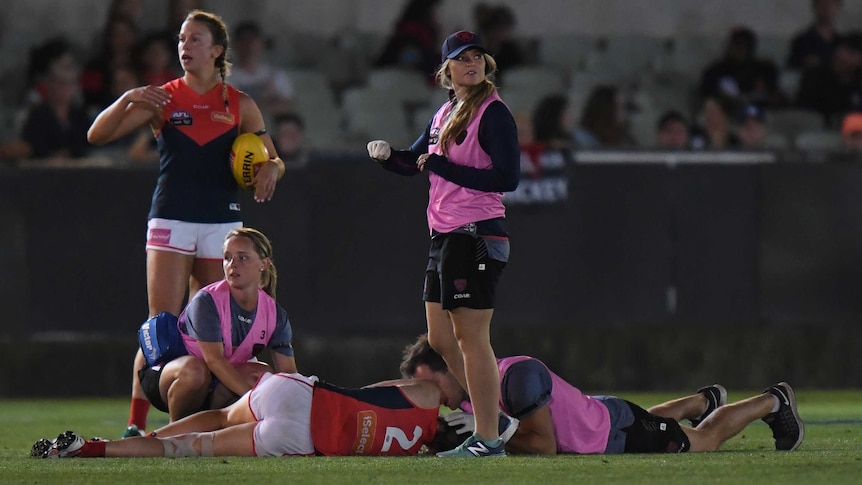 Melbourne's Meg Downie on ground after being knocked out against Collingwood on February 11, 2017.