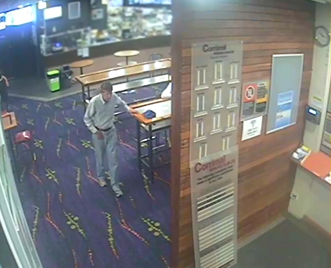 Visión de seguridad granulada de un hombre con jeans y camisa blanca en un pub