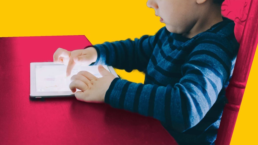 A small child sitting at a table using a tablet. Youngsters' screentime consumption is a big matter on concern for parents