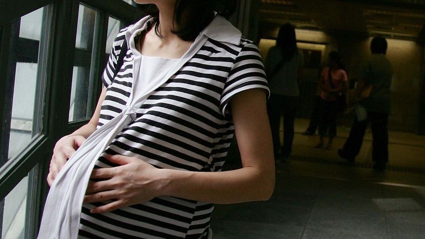 A pregnant woman holds her belly