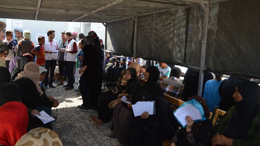 Women and children wait for a consultation in a shelter at the displaced person's camp near Erbil  in Iraq