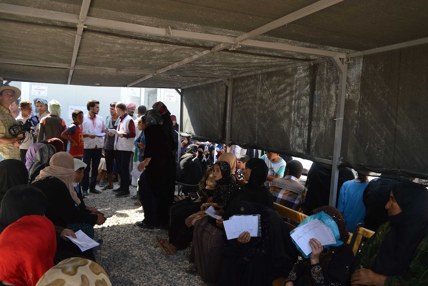 Women and children wait for a consultation in a shelter at the displaced person's camp near Erbil  in Iraq