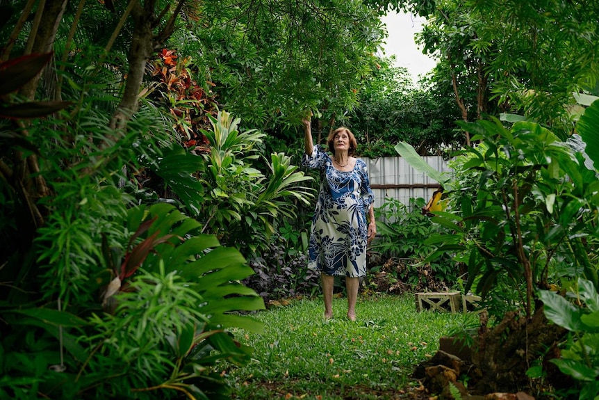 Wendy James stands in her luscious green backyard in Darwin