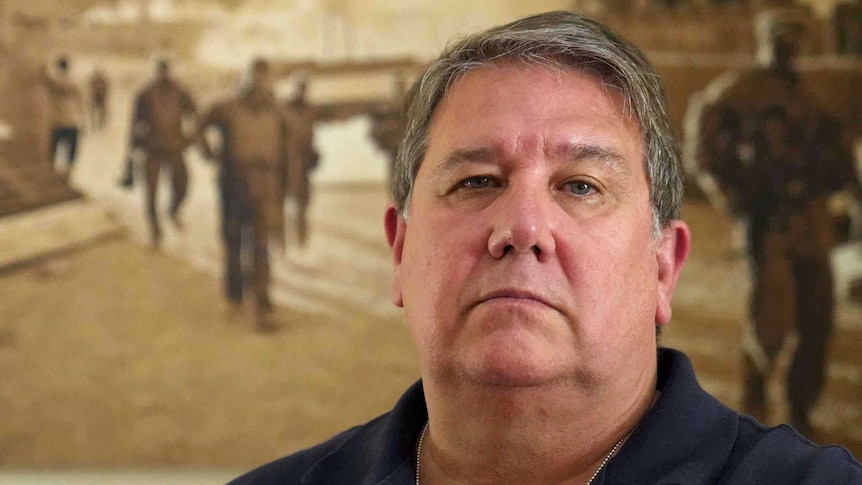 David Savage in front of a war mural