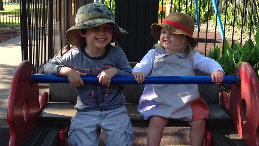 Two children sitting on play equipment