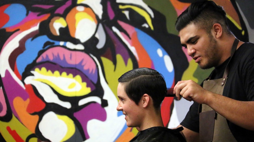 A customer gets a trim at a barbershop.