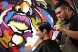 A customer gets a trim at a barbershop.