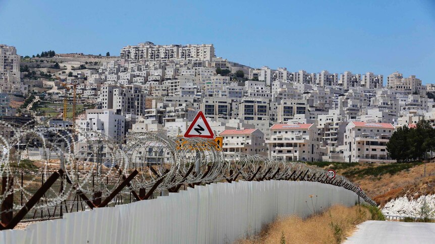 Razor wire covers a section of the controversial Israeli barrier near Har Homa