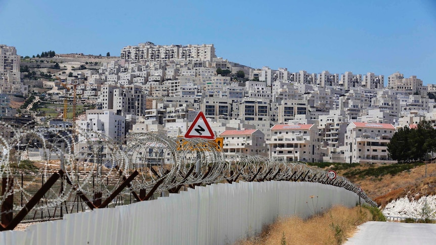 Razor wire covers a section of the controversial Israeli barrier near Har Homa