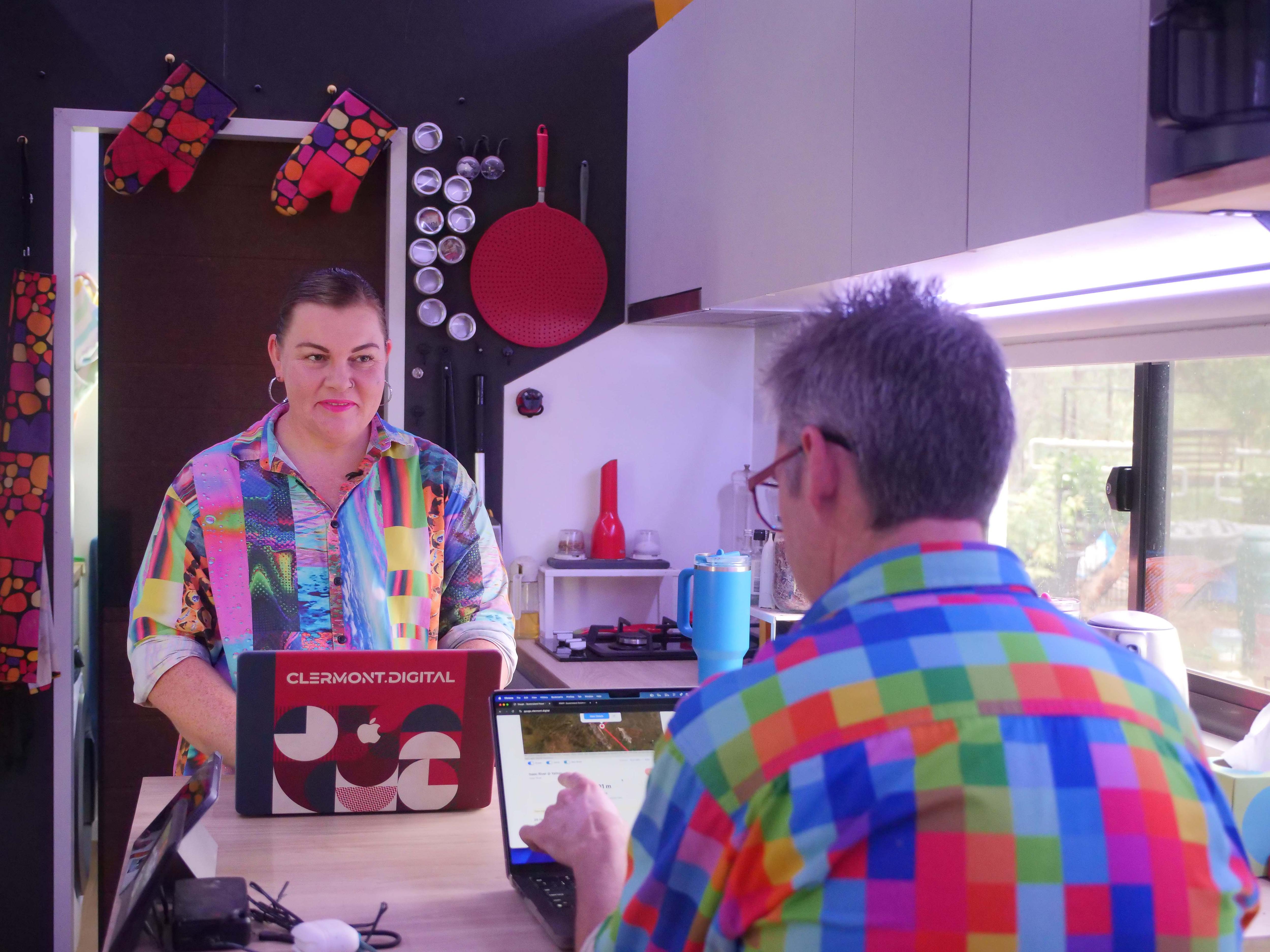Un hombre y una mujer se sientan en una mesa y trabajan en la computadora.