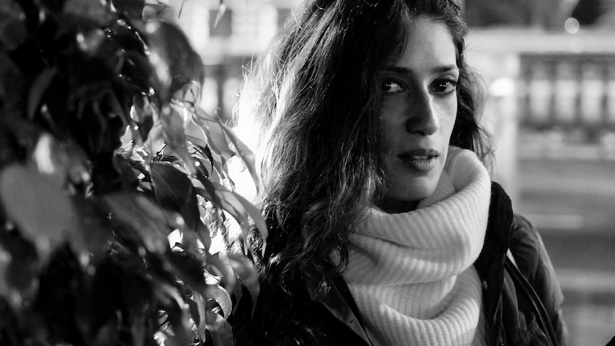 A B& W photo of Fatima Bhutto has her looking side on at the camera. She has long dark hair and dark eyes and wears a polo neck 