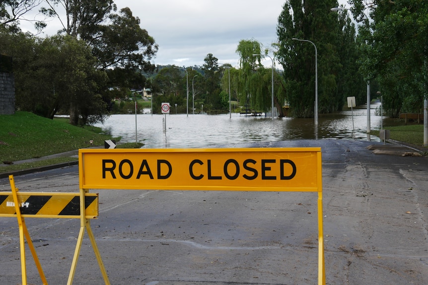 Panneau de fermeture de la route jaune et barrière à la route inondée.