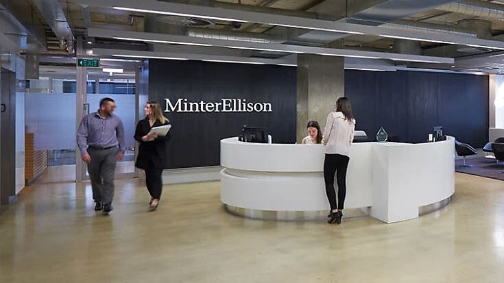foyer of law firm Minter Ellison featuring white reception desk and black wall with white text
