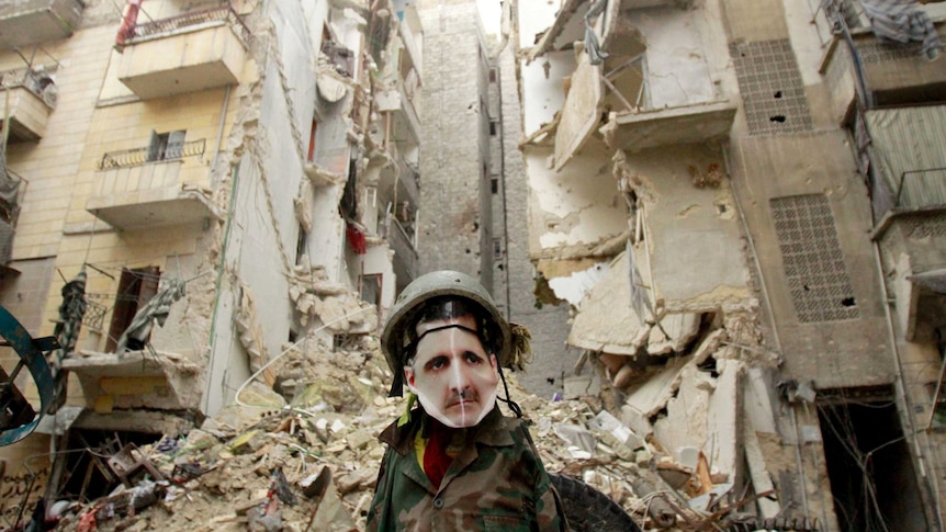 A dummy dressed in army fatigues and a mask showing Bashar al-Assad stands in Aleppo.