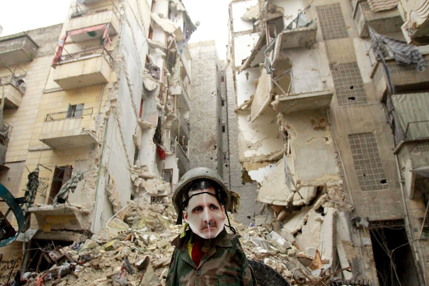 A dummy dressed in army fatigues and a mask showing Bashar al-Assad stands in Aleppo.