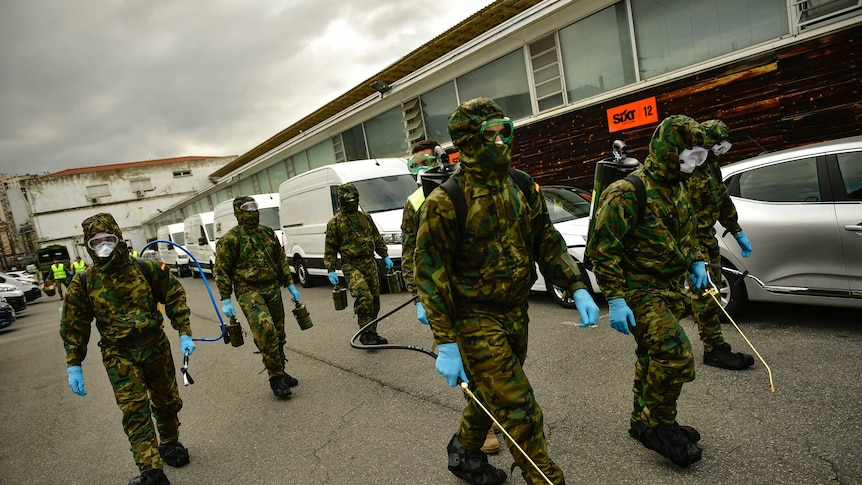 Member of Military Emergency Unit walk with special equipment to disinfect areas