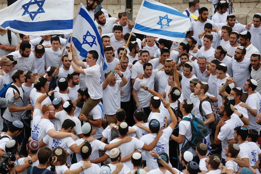 Israeli youths wave national flags outside the Old City's Damascus Gate.