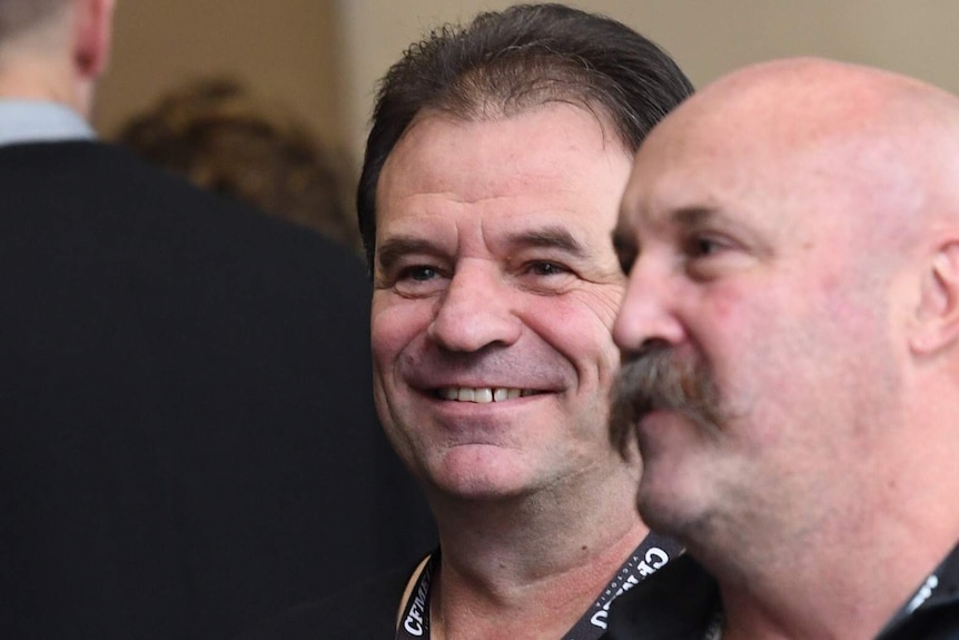 A smiling John Setka (centre) and Shaun Reardon arrive outside court.